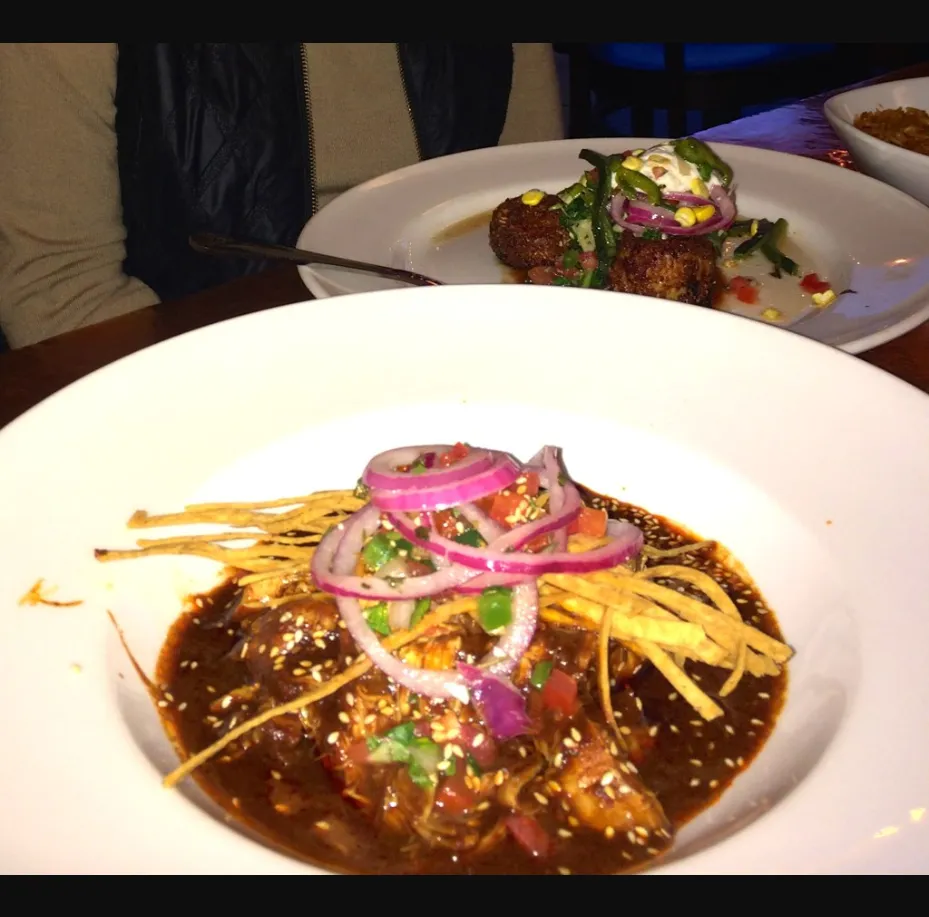 Elote Cafe signature mole dish with tortilla strips and pickled onions